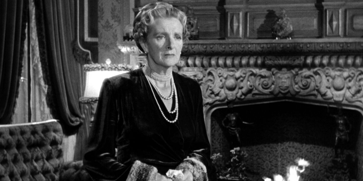 Gladys Cooper debout dans le salon près de la cheminée dans The Bishop's Wife (1947)