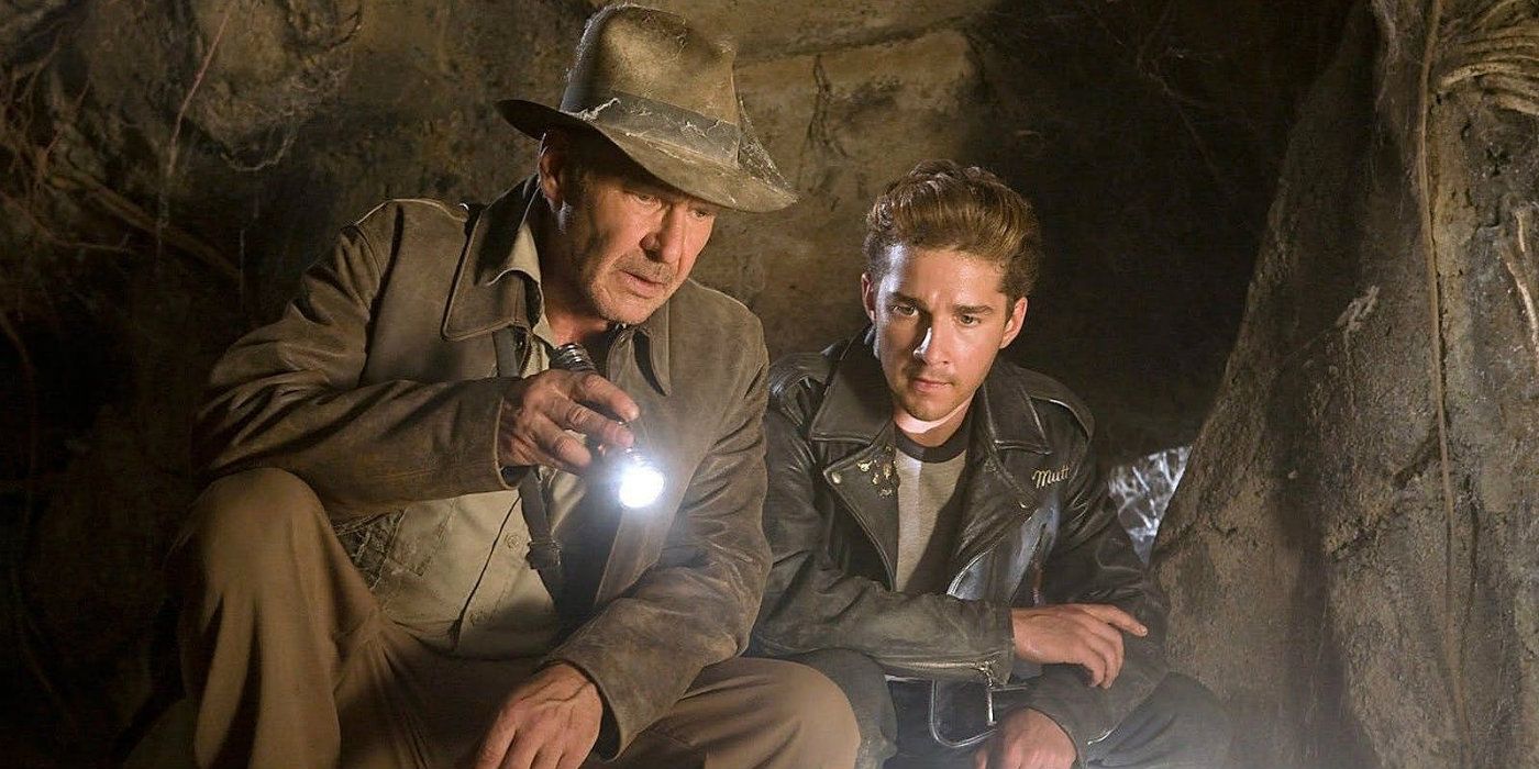 Harrison Ford dans Indiana Jones et Shia LaBeouf dans Mutt faisant briller une lampe de poche et examinant quelque chose dans une grotte dans 