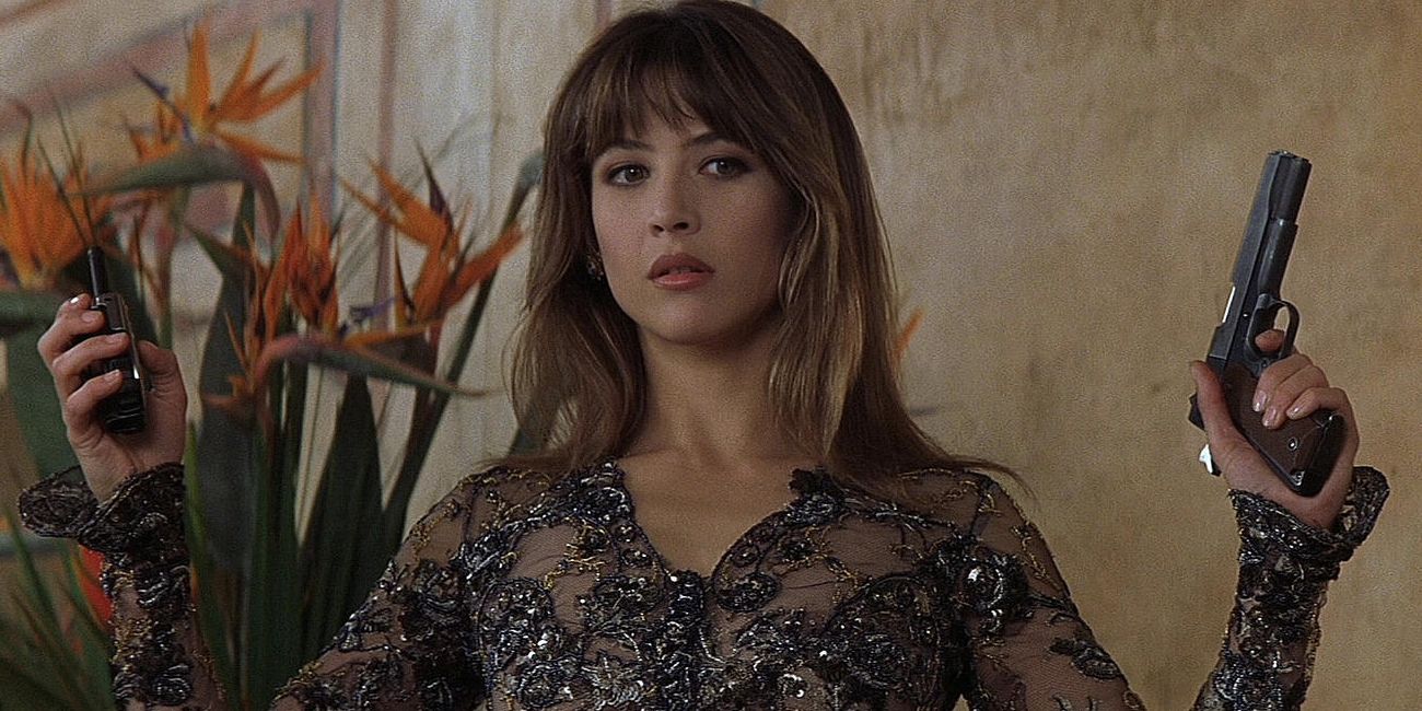 Elektra King (Sophie Marceau) tient une arme à feu et une radio alors qu'elle se moque de James Bond. 