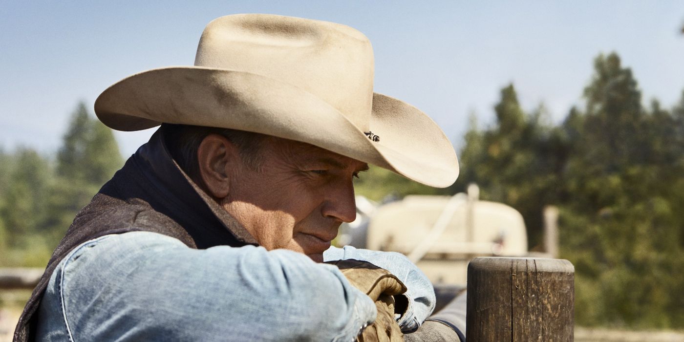 John Dutton (Kevin Costner) leans on a fence post in the