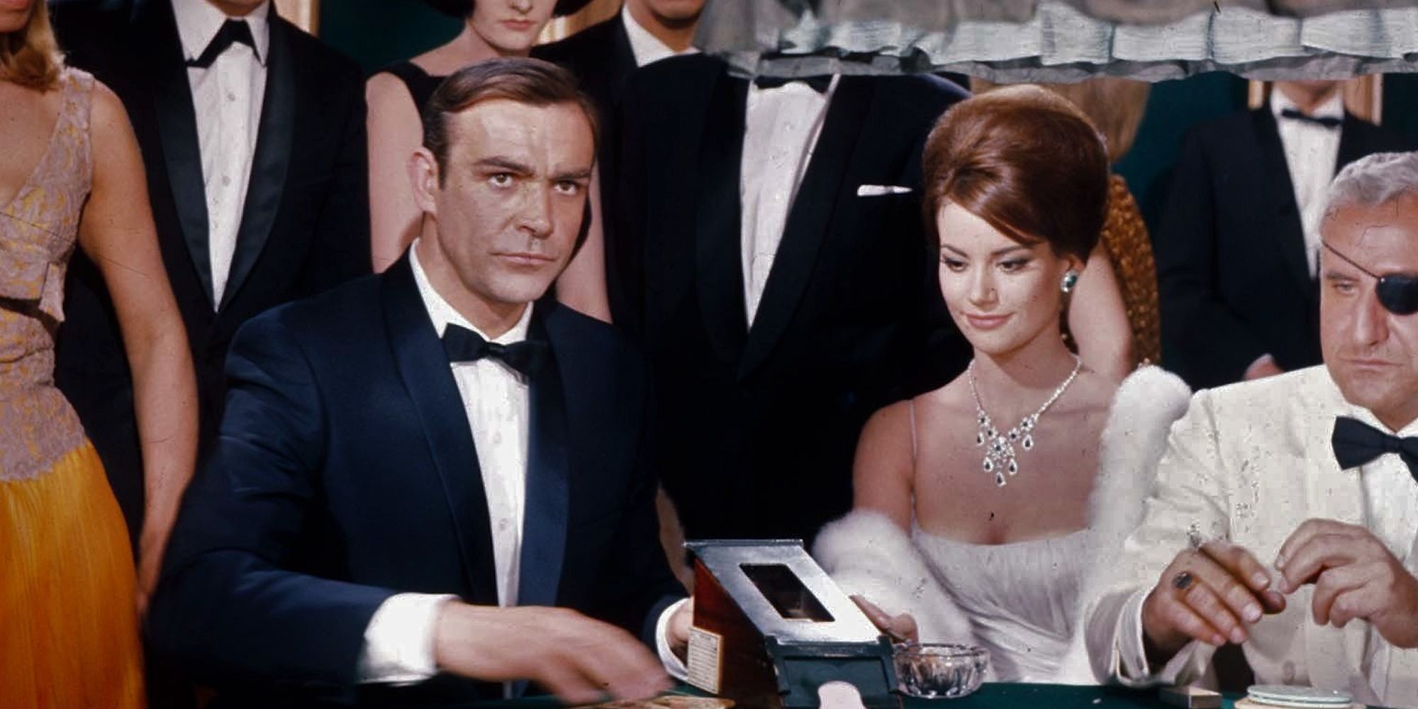 Sean Connery dans le rôle de James Bond sur une table de jeu entouré d'invités dans 