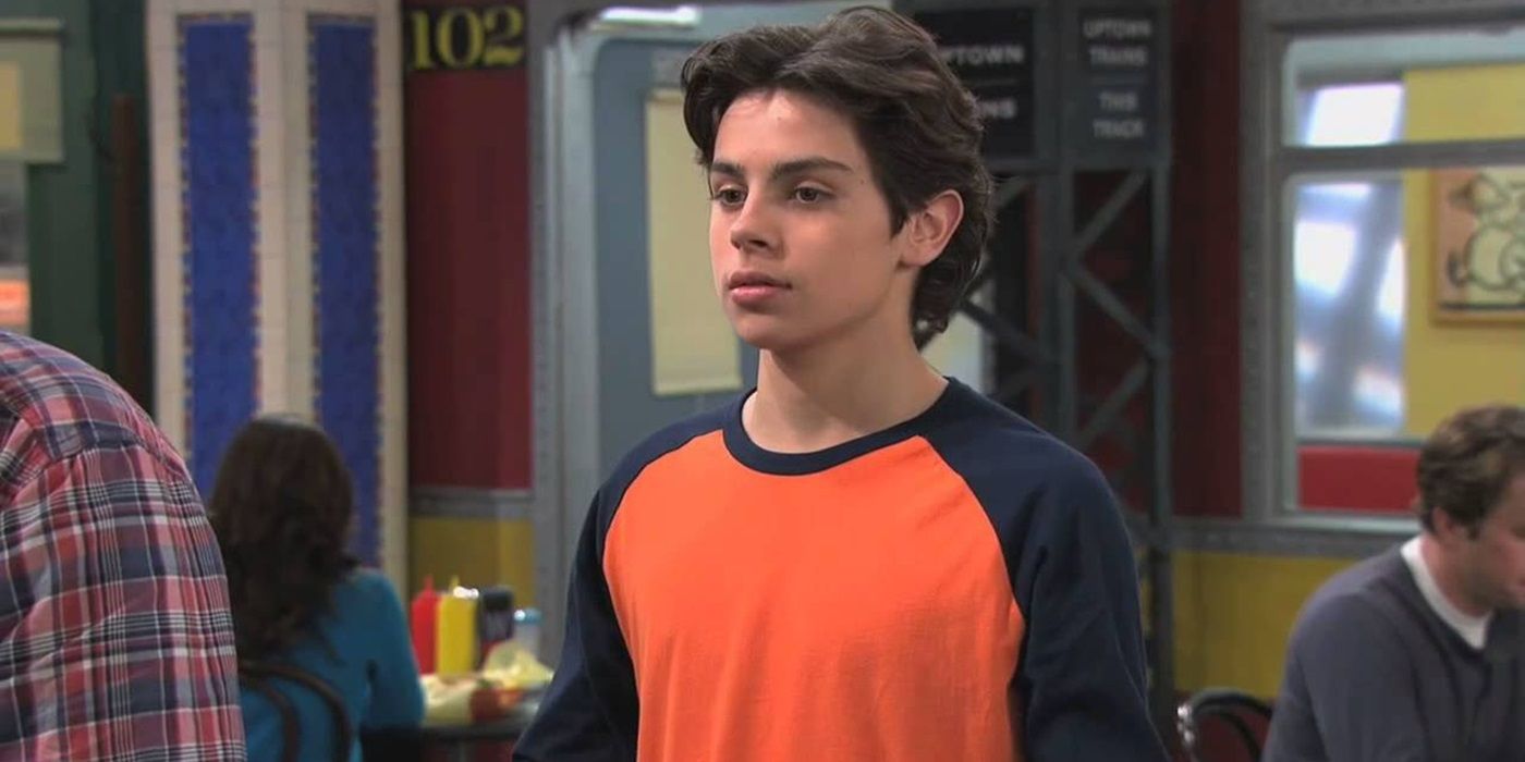 Jake T. Austin dans le rôle de Max Russo debout dans la boutique familiale des Sorciers de Waverly Place