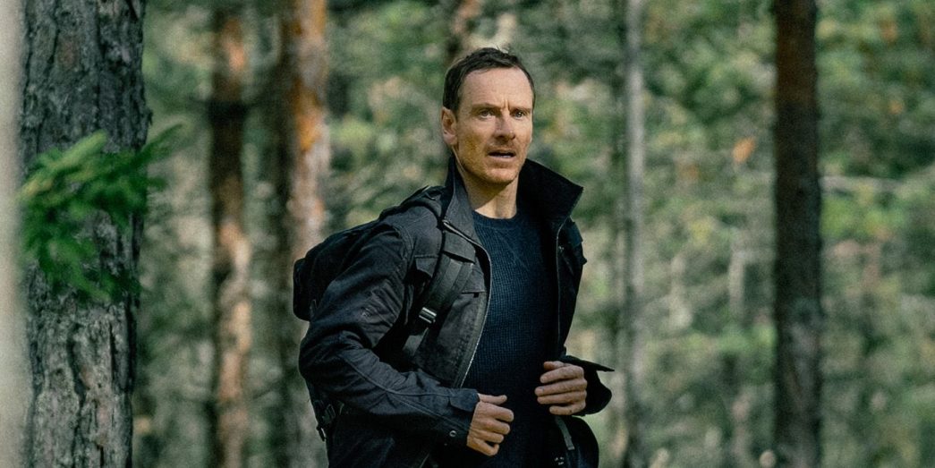 Michael Fassbender running through the woods in The Agency