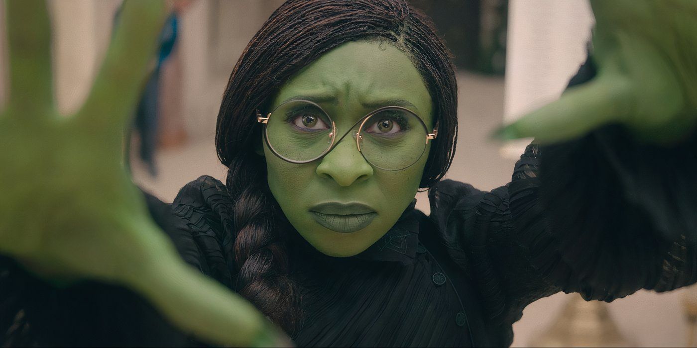 Cynthia Erivo dans le rôle d'Elphaba poussant ses mains tout en portant des lunettes dans Wicked.