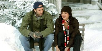 Lorelai (Lauren Graham) and Luke (Scott Patterson) smiling while putting on ice skates in Gilmore Girls.