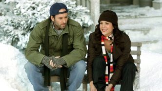 Lorelai (Lauren Graham) and Luke (Scott Patterson) smiling while putting on ice skates in Gilmore Girls.