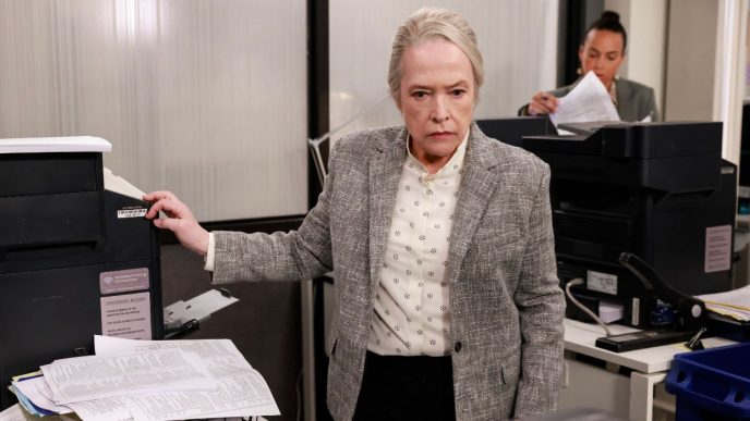 Kathy Bates standing at a printer