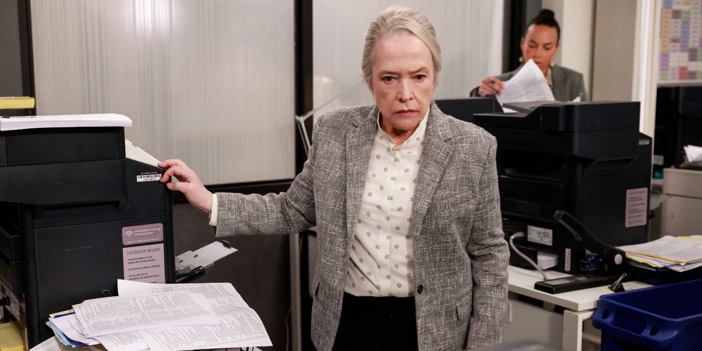 Kathy Bates standing at a printer