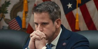 Adam Kinzinger sits, hands folded at his chin, in The Last Republican